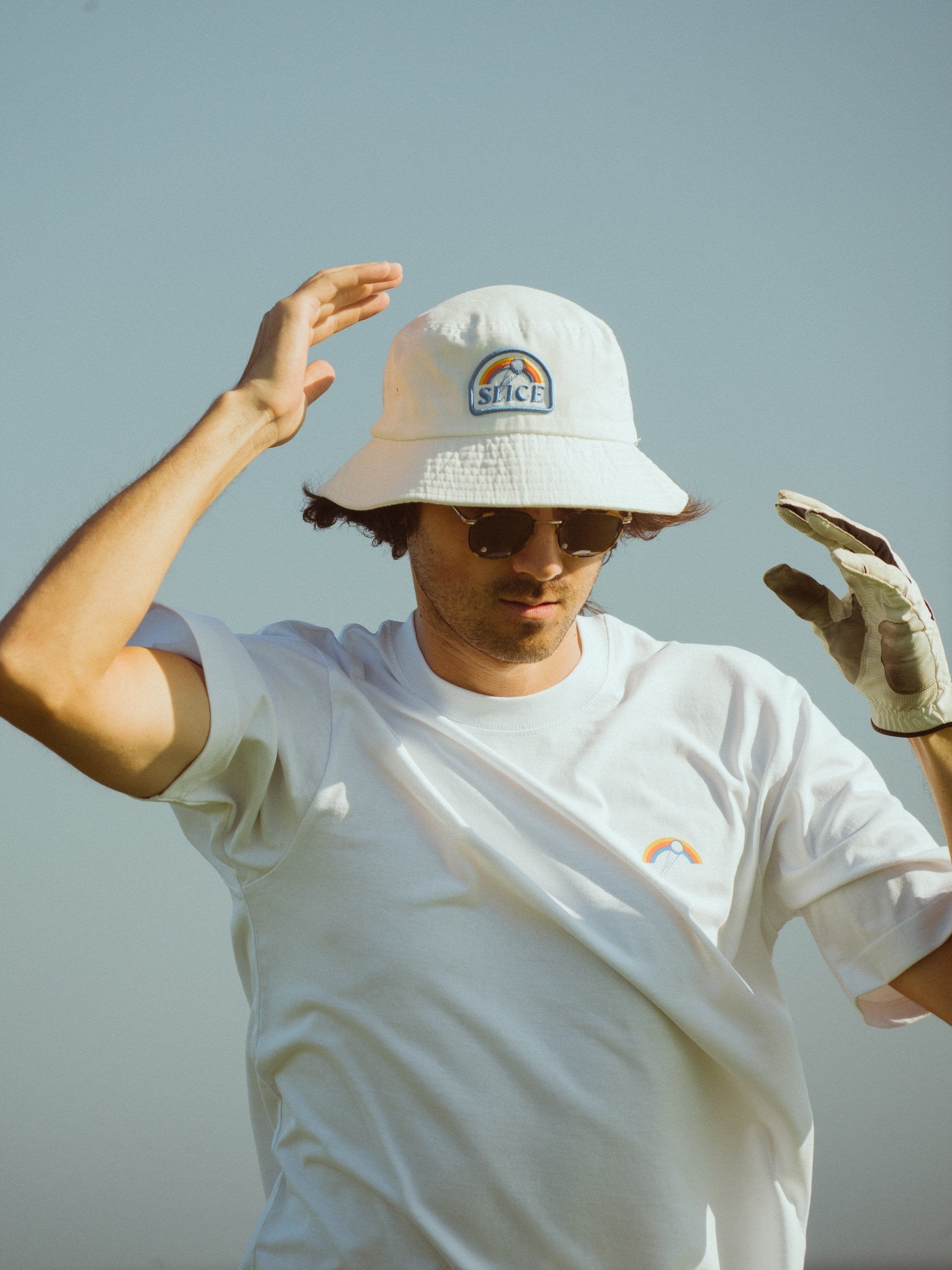Golf bucket hat in white with Slice logo on front on model.