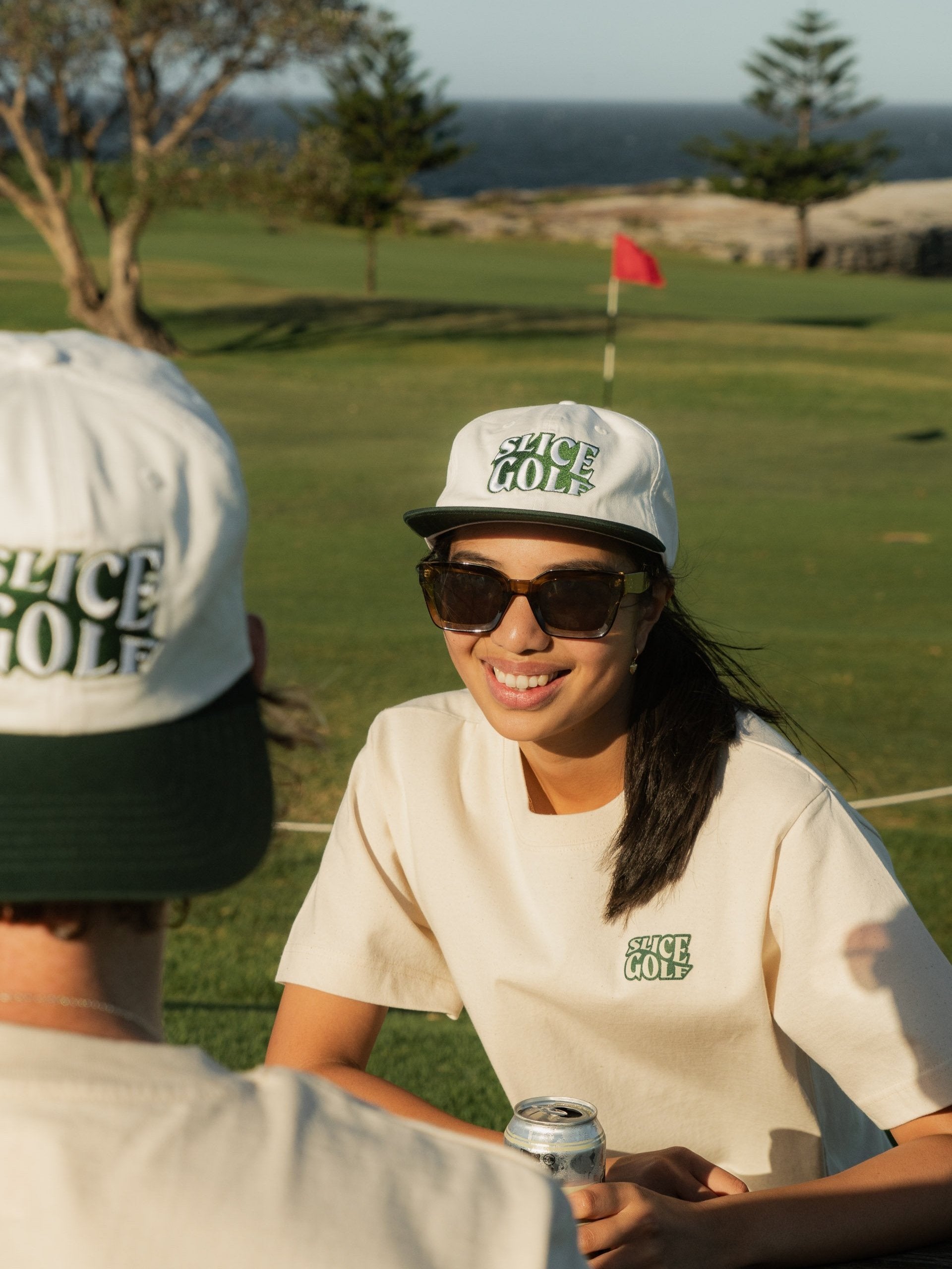 Golf cap in white and green - on female model wearing a Slice Golf T-shirt