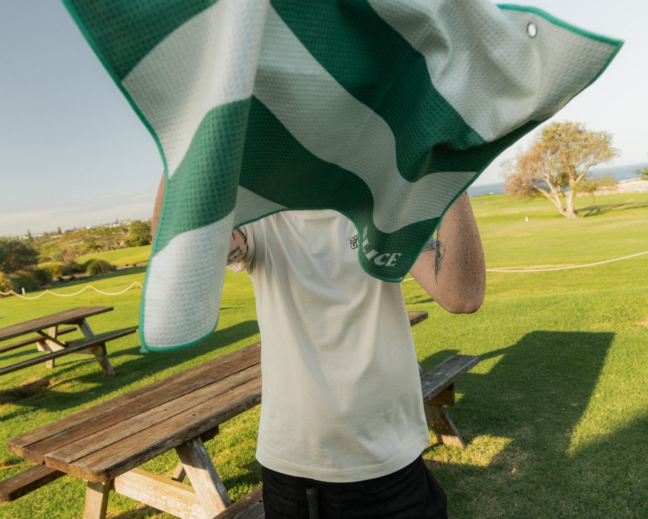 Golf towel in white and green in front of model