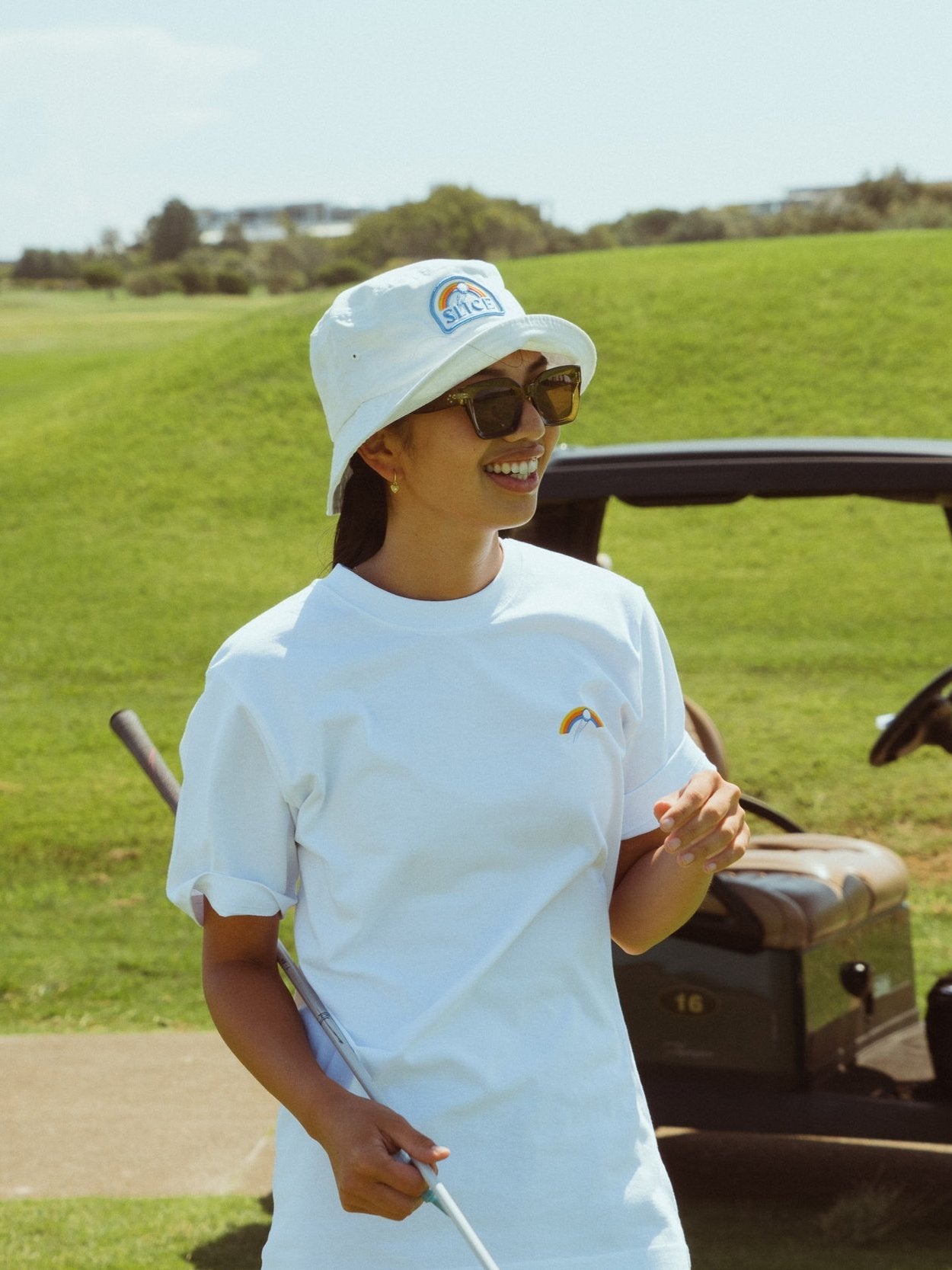 Golf bucket hat in white with Slice logo on front on model.