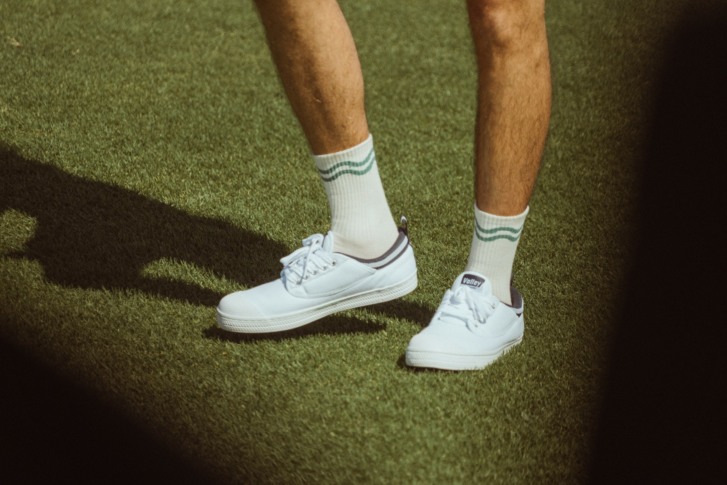 Golf sports socks in off-white and green with green wavy lines shown on male model
