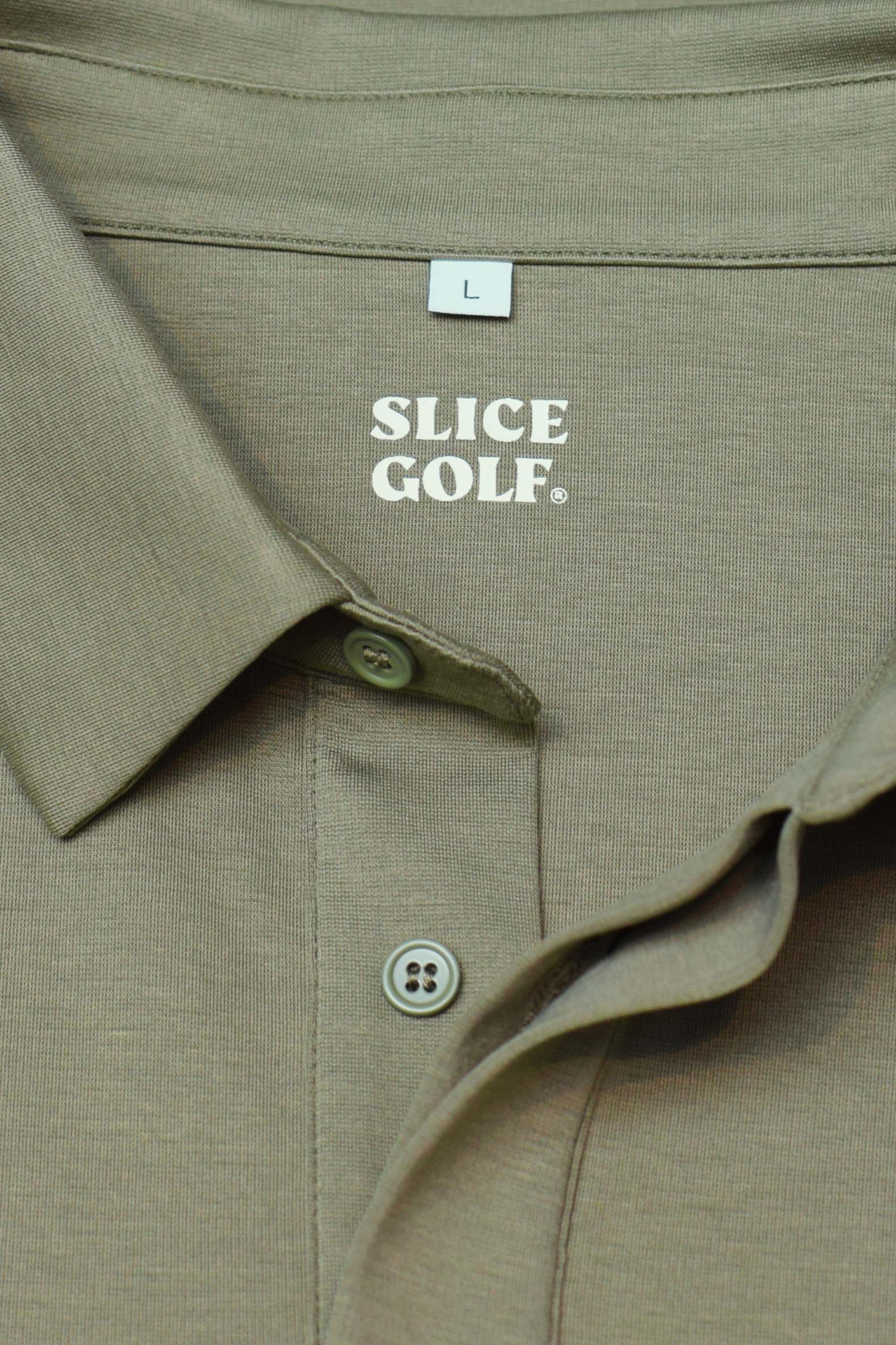Green polo shirt with 'Slice Golf' label on a textured surface