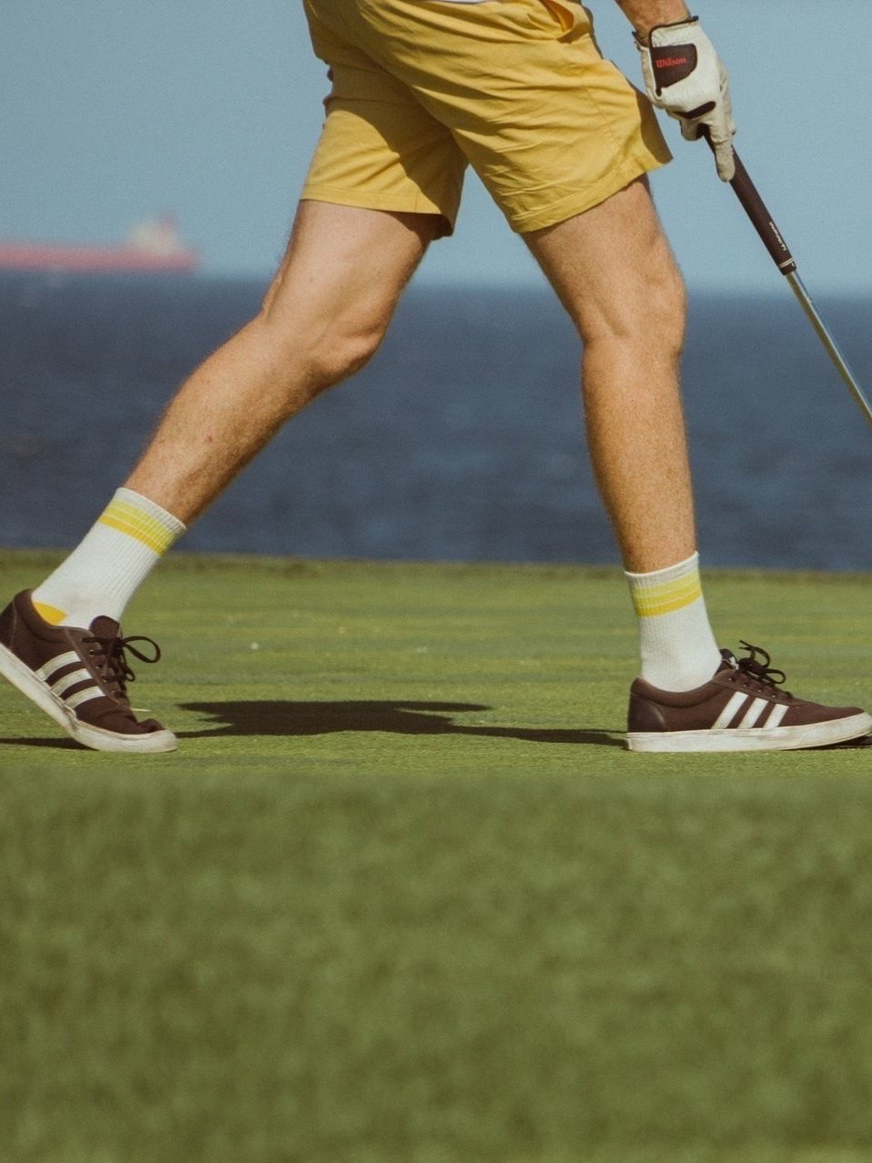 Golf sports socks in white with yellow stripes on model.